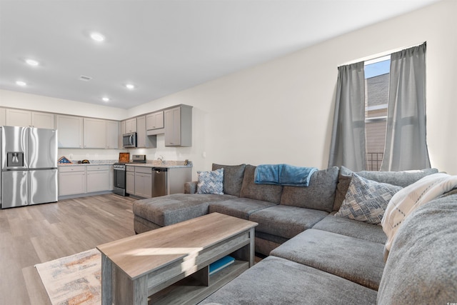 living area with light wood-style floors and recessed lighting