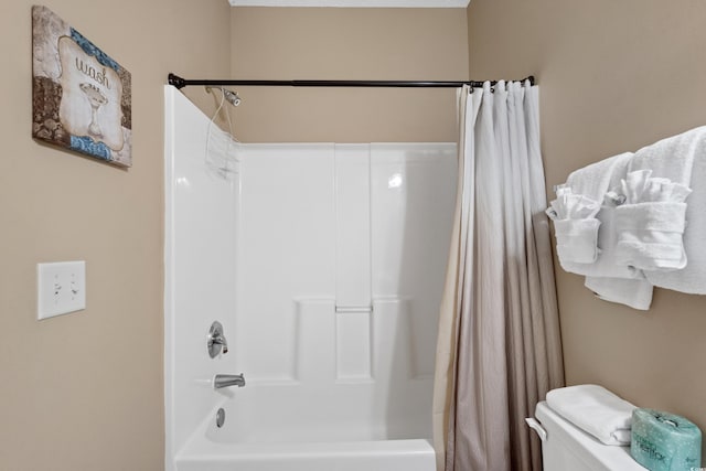 bathroom with shower / tub combo with curtain and toilet