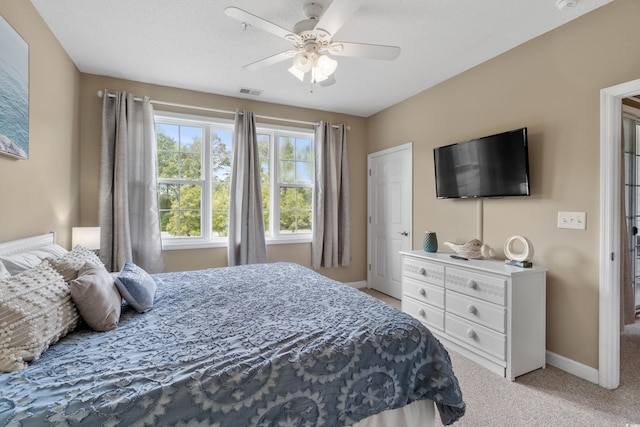 bedroom featuring a ceiling fan, baseboards, visible vents, and carpet