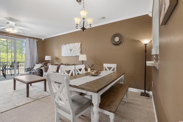 dining space featuring visible vents, crown molding, ceiling fan with notable chandelier, and light carpet