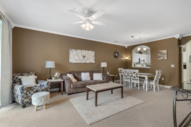 carpeted living area featuring crown molding, baseboards, and ceiling fan with notable chandelier