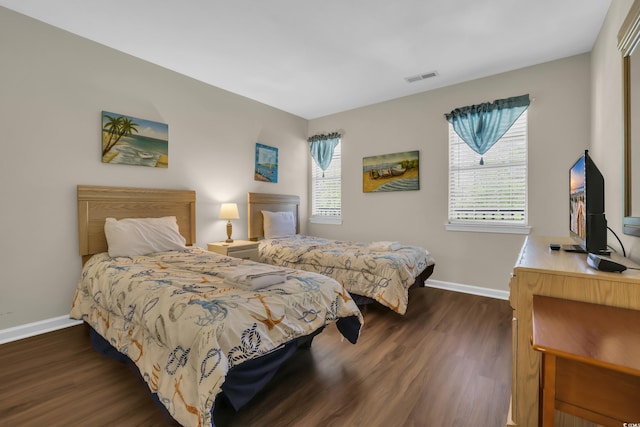 bedroom featuring baseboards, visible vents, and dark wood-type flooring