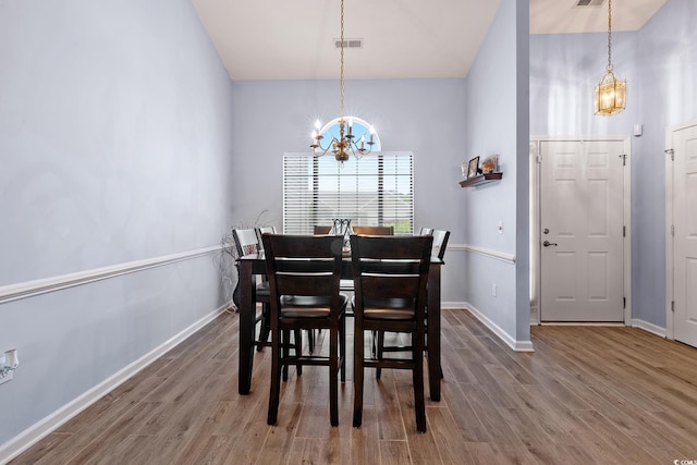 1752 Starbridge Dr, Surfside Beach, SC 29575 - dining room featuring baseboards, an inviting chandelier, visible vents, lofted ceiling, and wood finished floors
