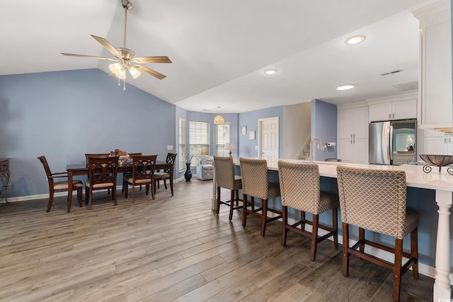 1752 Starbridge Dr, Surfside Beach, SC 29575 - kitchen with white cabinets, light countertops, a kitchen breakfast bar, light wood finished floors, and smart refrigerator