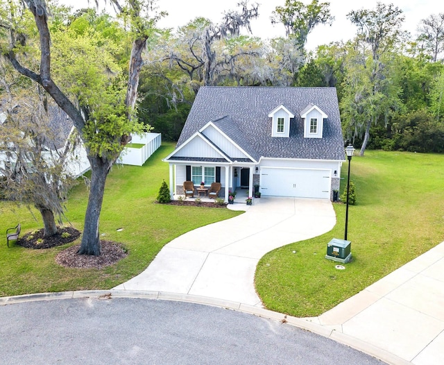 view of front of property with covered porch, a front yard, driveway, and roof with shingles