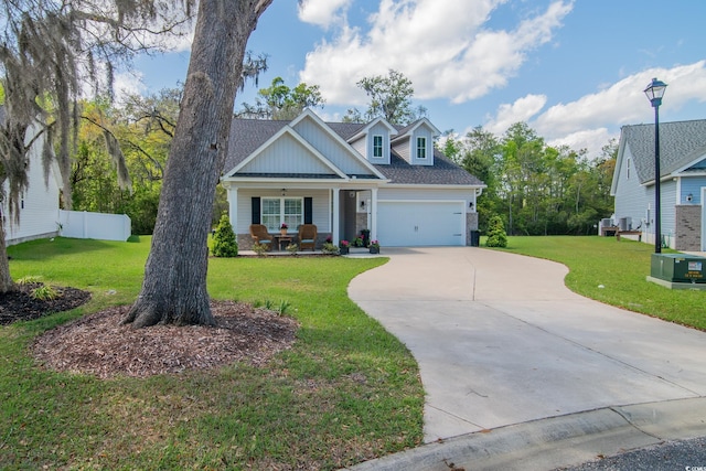 view of front facade with a porch, concrete driveway, a front lawn, and fence