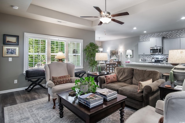 living room featuring baseboards, recessed lighting, dark wood-style floors, visible vents, and a ceiling fan