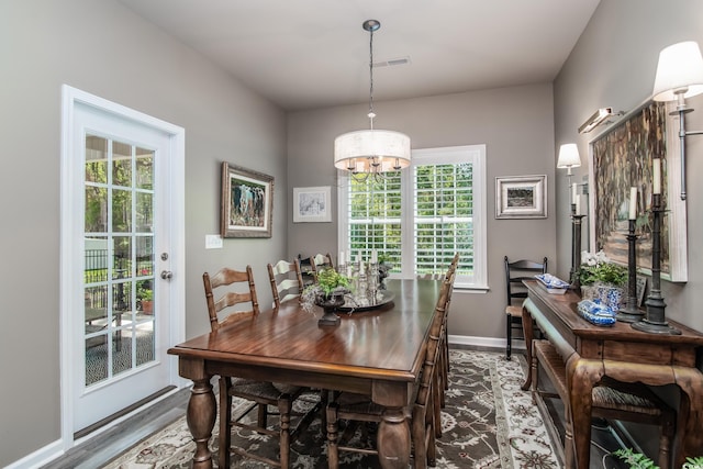 dining area with a notable chandelier, wood finished floors, and baseboards