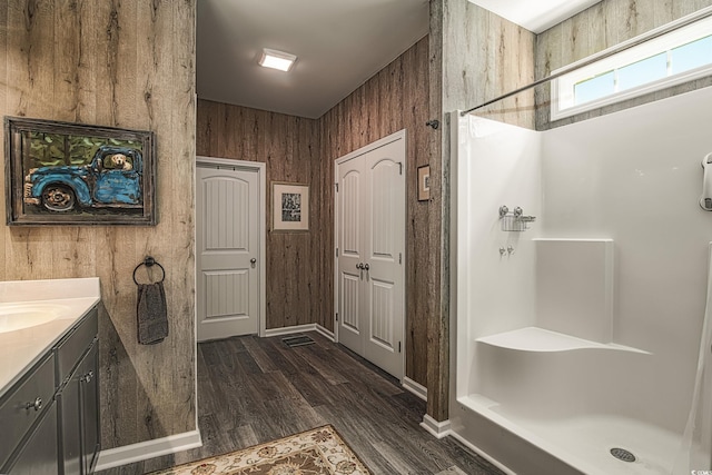 bathroom featuring vanity, a shower stall, and wood finished floors