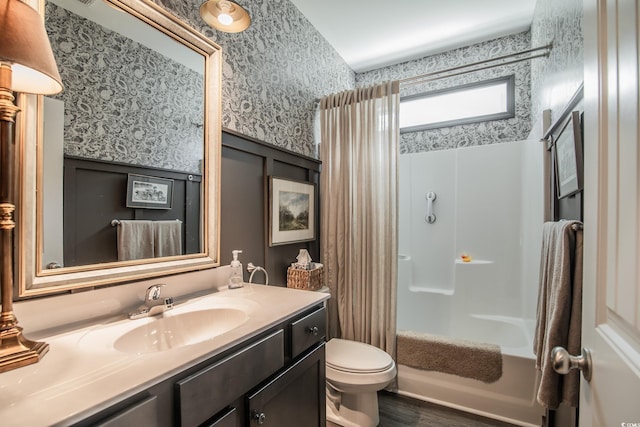 bathroom featuring wood finished floors, wallpapered walls, toilet, vanity, and shower / tub combo with curtain