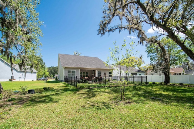 back of house featuring a yard and fence