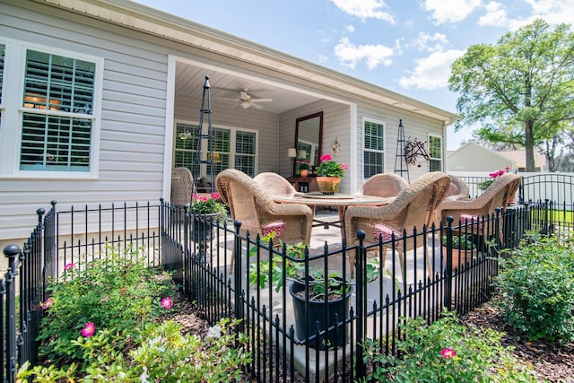 wooden terrace featuring fence, a ceiling fan, and a patio