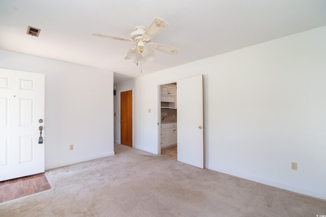391 Waterford Dr, Georgetown, SC 29440 - spare room featuring light colored carpet, a ceiling fan, a sink, and baseboards