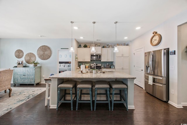 181 Ocean Commons Dr, Surfside Beach, SC 29575 - kitchen featuring tasteful backsplash, appliances with stainless steel finishes, white cabinetry, and a breakfast bar