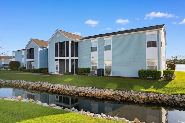 view of building exterior featuring central air condition unit and a water view