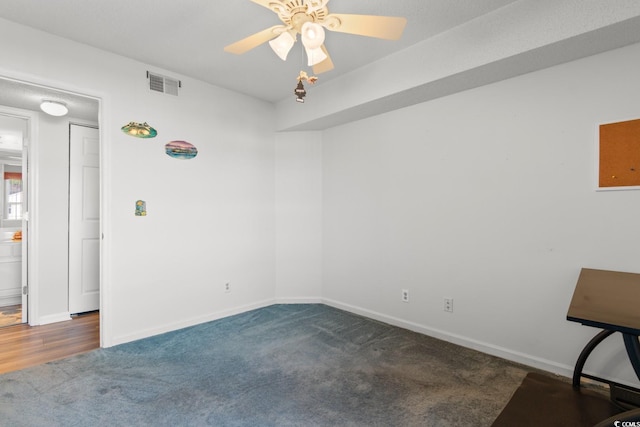 unfurnished room featuring carpet floors, a ceiling fan, visible vents, and baseboards