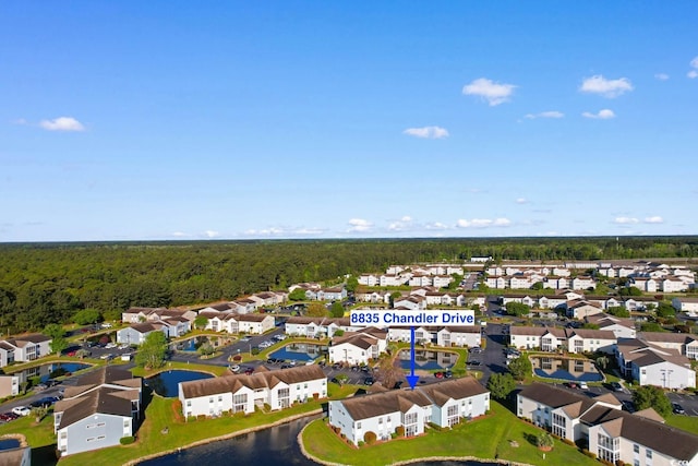 drone / aerial view with a forest view, a water view, and a residential view