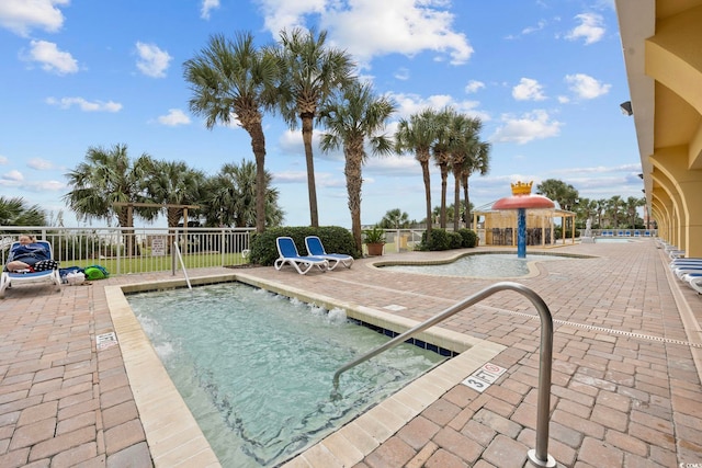 community pool featuring fence and a patio