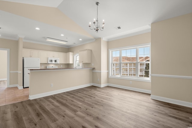 117 S Shore Blvd Unit 301, Longs, SC 29568 - kitchen featuring white appliances, ornamental molding, a chandelier, a peninsula, and light wood-style flooring