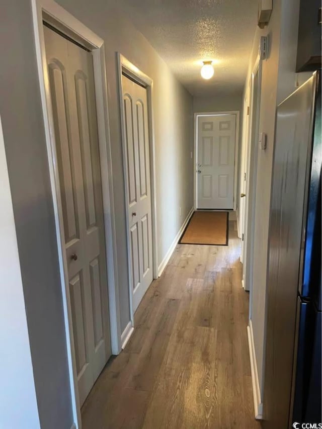 500 Fairway Village Dr Unit 3I, Myrtle Beach, SC 29588 - hall with a textured ceiling, wood finished floors, and baseboards
