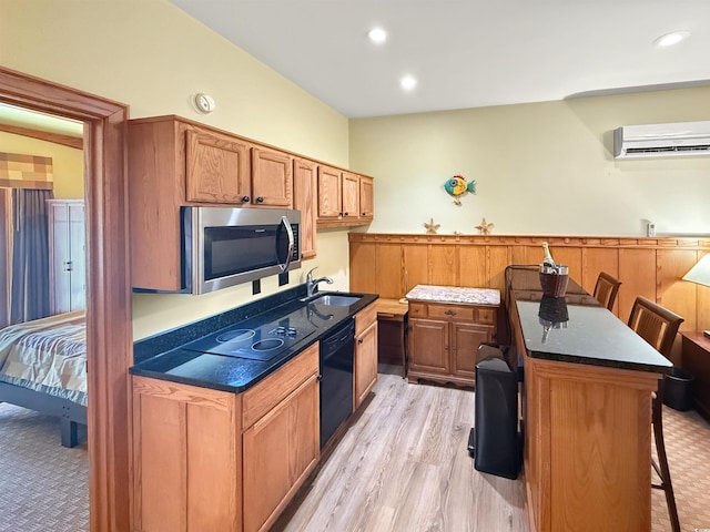 147 Brown Pelican Loop, Pawleys Island, SC 29585 - kitchen with black appliances, a wall mounted air conditioner, a breakfast bar, light wood-type flooring, and brown cabinets