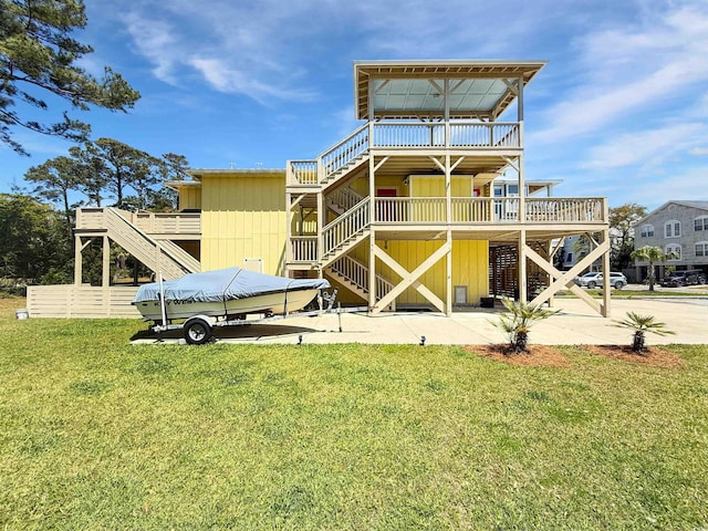 147 Brown Pelican Loop, Pawleys Island, SC 29585 - back of house featuring stairs, a lawn, a deck, and a patio