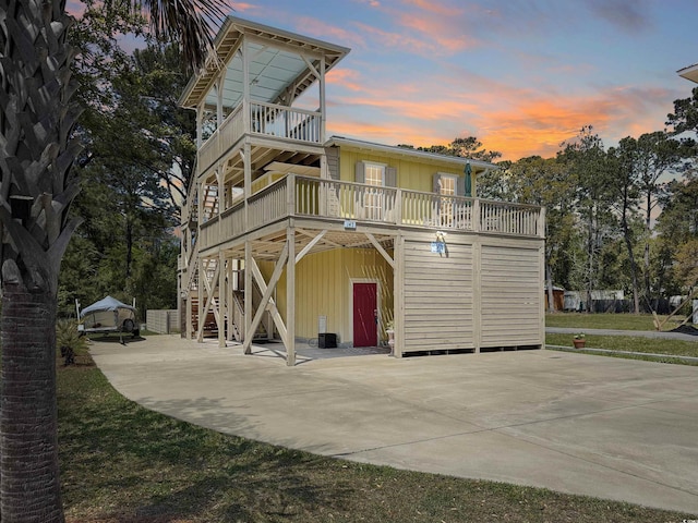 147 Brown Pelican Loop, Pawleys Island, SC 29585 - view of front of house with driveway, a balcony, board and batten siding, and stairway