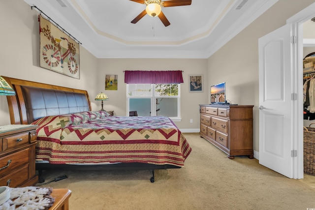 bedroom with ceiling fan, visible vents, crown molding, a raised ceiling, and light carpet