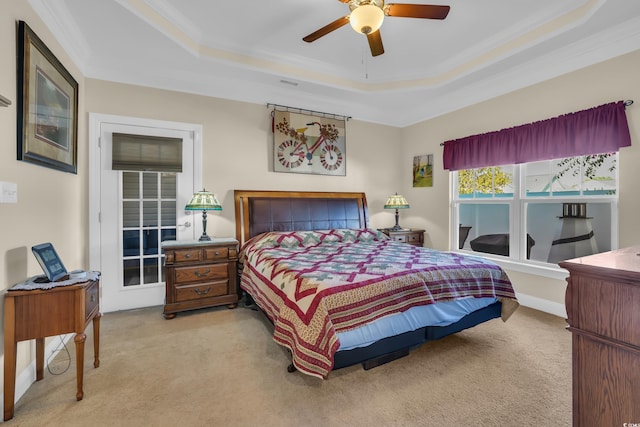 bedroom with ornamental molding, a tray ceiling, ceiling fan, and light colored carpet