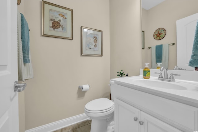 bathroom with vanity, tile patterned flooring, baseboards, and toilet
