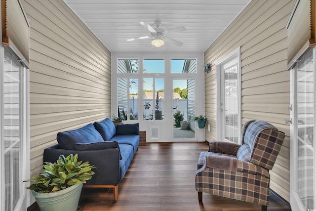 sunroom featuring wooden walls, ceiling fan, and hardwood / wood-style flooring