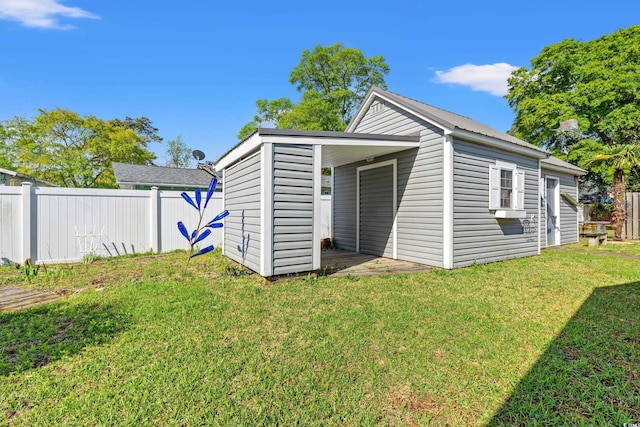 view of outdoor structure with fence and an outbuilding