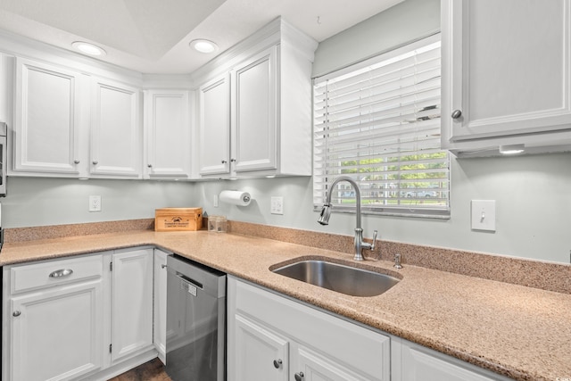 kitchen with stainless steel dishwasher, light stone countertops, recessed lighting, white cabinets, and a sink