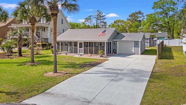 view of front of house featuring driveway, a sunroom, a garage, fence, and a front lawn