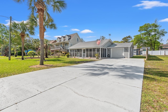 view of front of home featuring driveway, a front yard, a sunroom, fence, and an attached garage