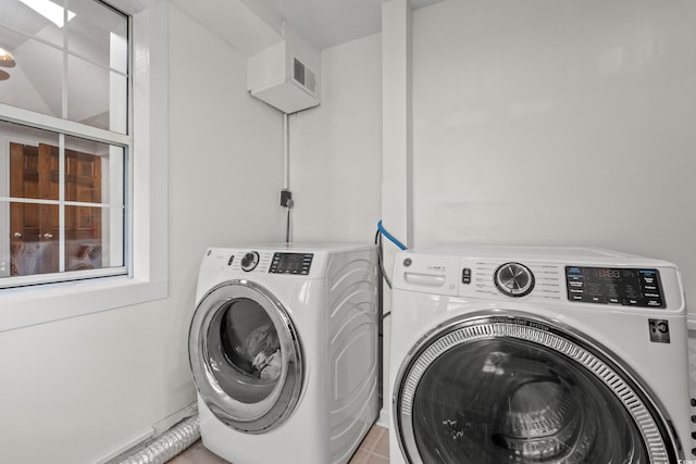 laundry room featuring laundry area, independent washer and dryer, and light tile patterned flooring
