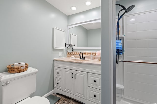 bathroom with vanity, toilet, baseboards, a shower, and backsplash