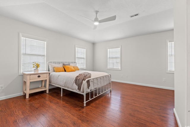 bedroom with ceiling fan, baseboards, visible vents, and wood finished floors