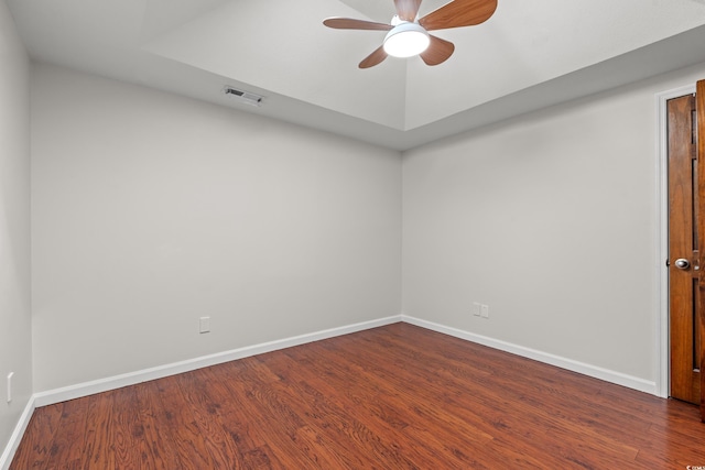 unfurnished room with baseboards, a ceiling fan, dark wood finished floors, and visible vents