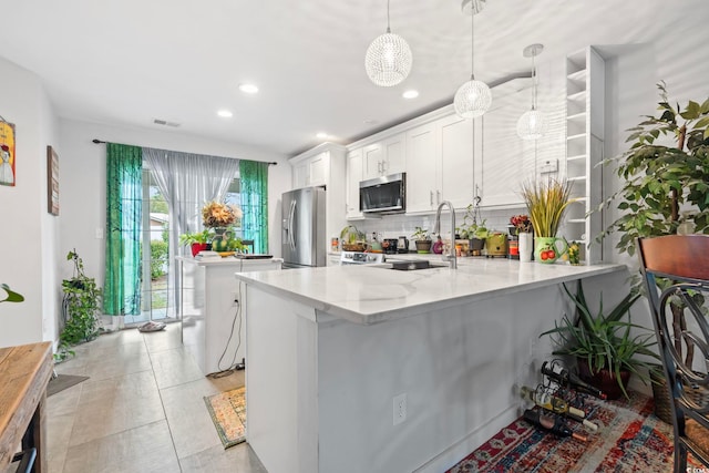 3564 Evergreen Way Unit 3564, Myrtle Beach, SC 29577 - kitchen featuring stainless steel appliances, backsplash, a peninsula, white cabinetry, and decorative light fixtures
