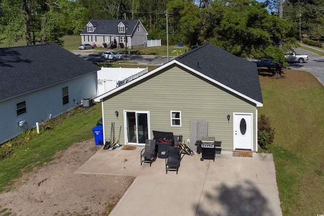 rear view of property featuring a patio, a lawn, and central air condition unit