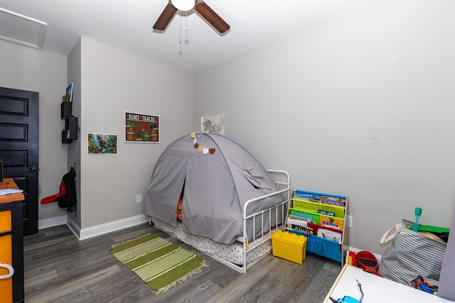 bedroom featuring baseboards, attic access, a ceiling fan, and wood finished floors
