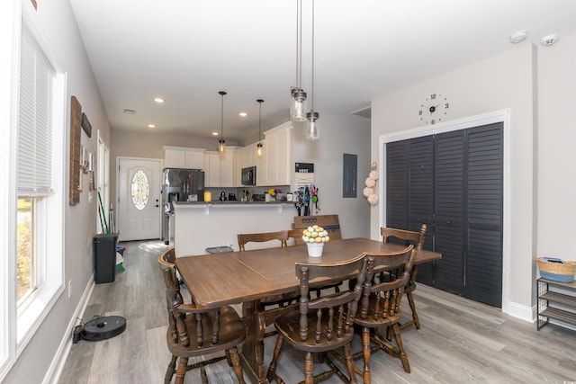 dining area featuring light wood-type flooring, recessed lighting, baseboards, and electric panel