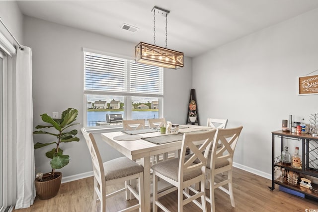 dining space featuring baseboards, visible vents, and light wood-style floors