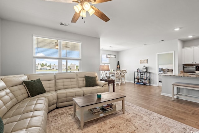 living room with recessed lighting, a ceiling fan, visible vents, baseboards, and wood finished floors