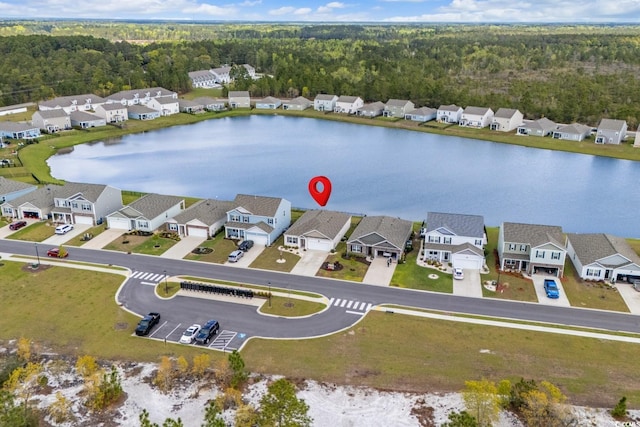 birds eye view of property featuring a residential view, a water view, and a wooded view