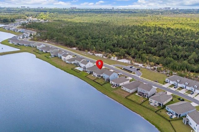 drone / aerial view with a water view, a view of trees, and a residential view