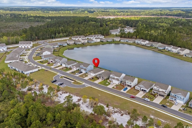 birds eye view of property featuring a water view, a residential view, and a forest view
