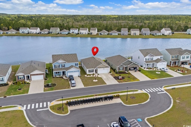 birds eye view of property featuring a wooded view, a residential view, and a water view