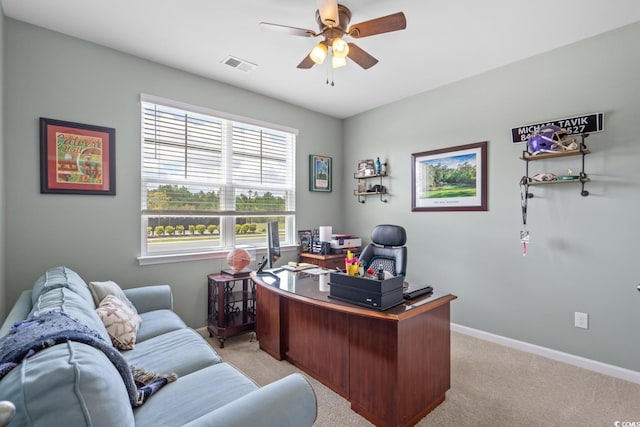 office area with baseboards, visible vents, ceiling fan, and light colored carpet